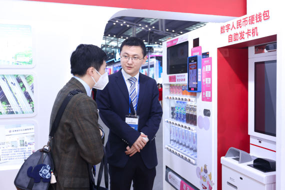 图为中国银行工作人员为客户介绍数字人民币硬钱包自助发卡机的使用。(中国银行供图).jpg